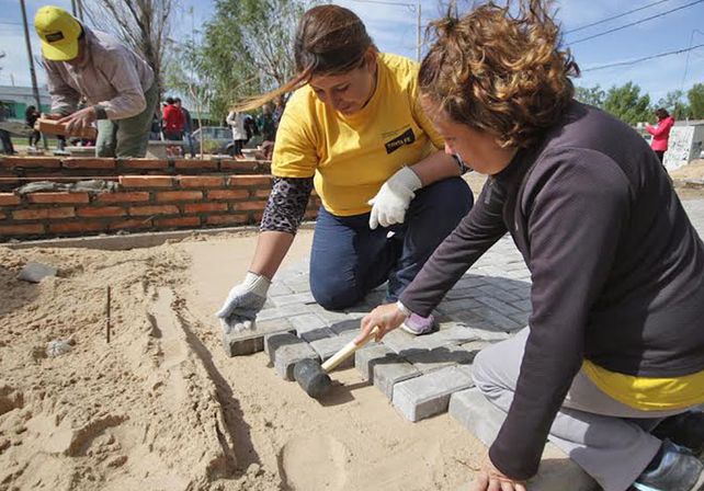 Con orgullo, seis mujeres realizan las veredas de la plaza