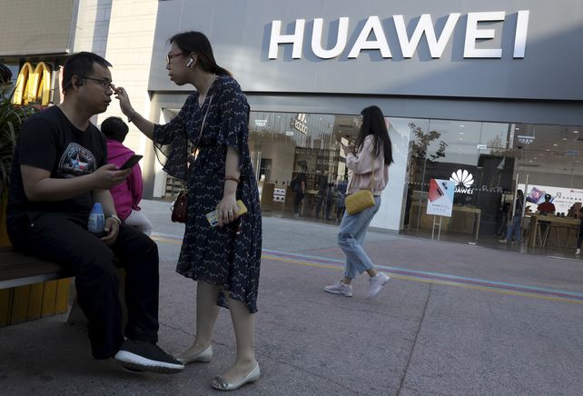 ¿Y ahora? Una pareja ante un negocio de Huawei en Pekín.