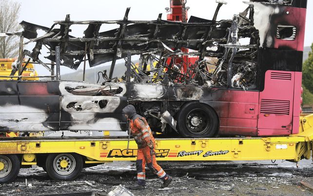 Restos de un autobús de dos pisos quemado se retiran de una carretera principal en el norte de Belfast, Irlanda del Norte. El autobús fue secuestrado e incendiado el domingo por cuatro hombres que abordaron el autobús y ordenaron a los pasajeros descender.