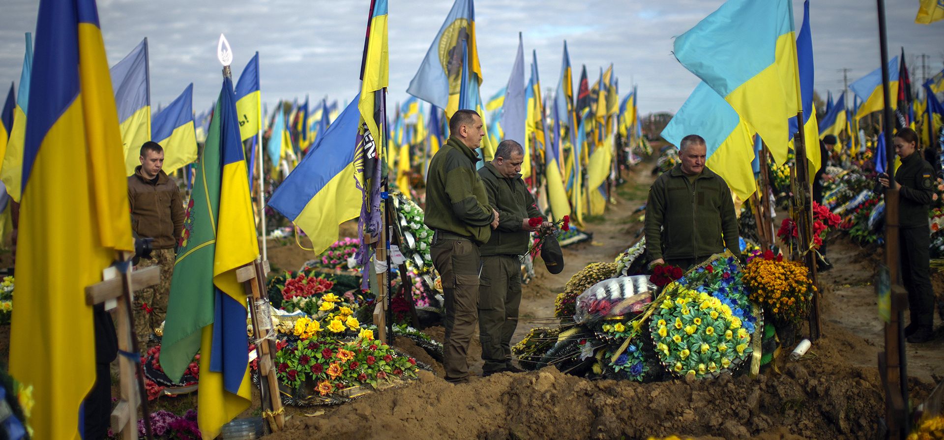 Militares ucranianos colocan flores en la tumba de un compañero soldado asesinado recientemente en un cementerio, durante el Día de los Defensores de Ucrania en Kharkiv, Ucrania, el viernes 14 de octubre de 2022.