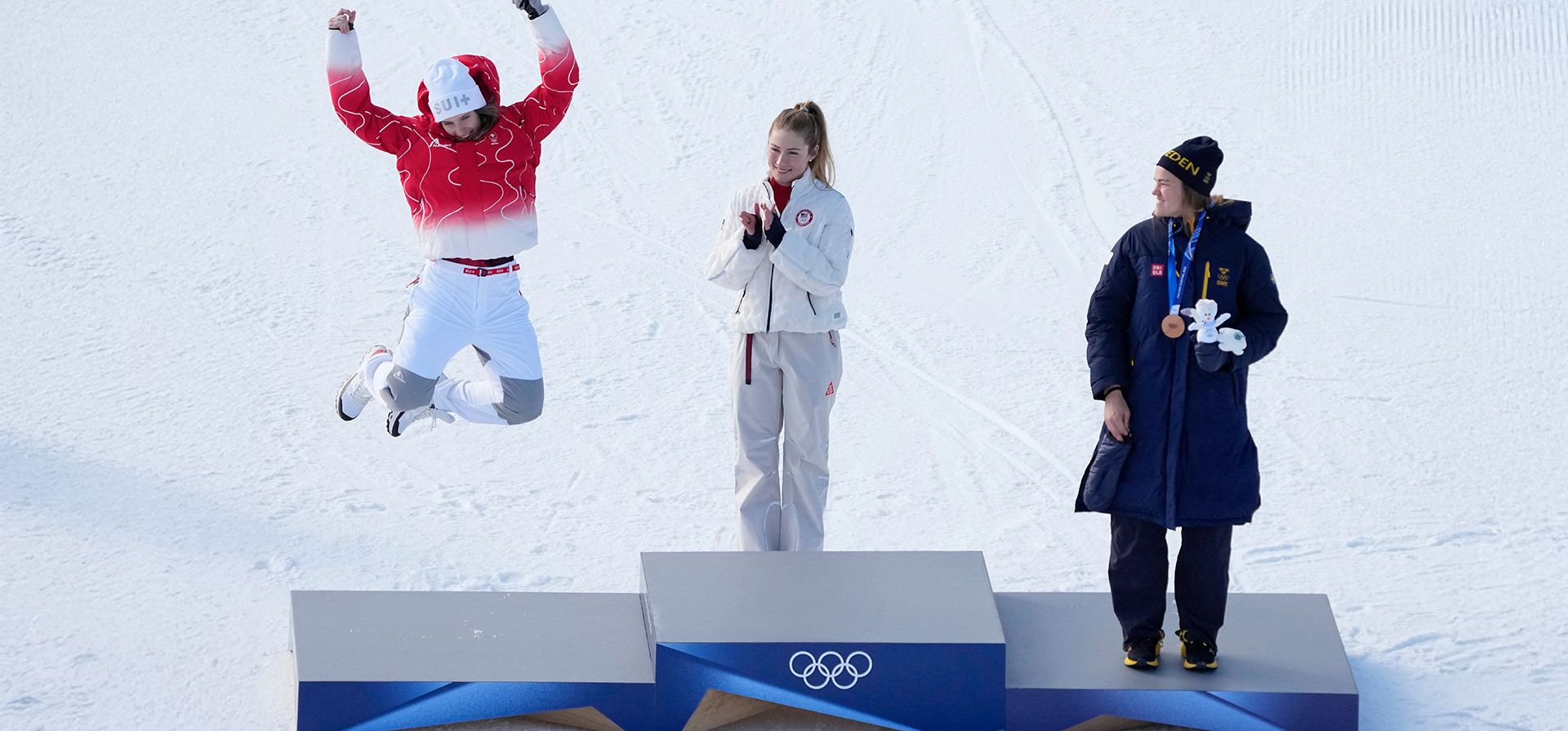 La suiza Camille Rast (izquierda) celebra su medalla de plata en el eslalon femenino de esquí alpino, mientras la medallista de oro estadounidense Mikaela Shiffrin (centro) y la medallista de bronce sueca Anna Swenn Larsson observan en los Juegos Olímpicos de Invierno de 2026 en Cortina d'Ampezzo, Italia, el miércoles 18 de febrero de 2026. (Foto AP/Andy Wong) La suiza Camille Rast (izquierda) celebra su medalla de plata en el eslalon femenino de esquí alpino, mientras la medallista de oro estadounidense Mikaela Shiffrin (centro) y la medallista de bronce sueca Anna Swenn Larsson observan en los Juegos Olímpicos de Invierno de 2026 en Cortina d'Ampezzo, Italia, el miércoles 18 de febrero de 2026. (Foto AP/Andy Wong)