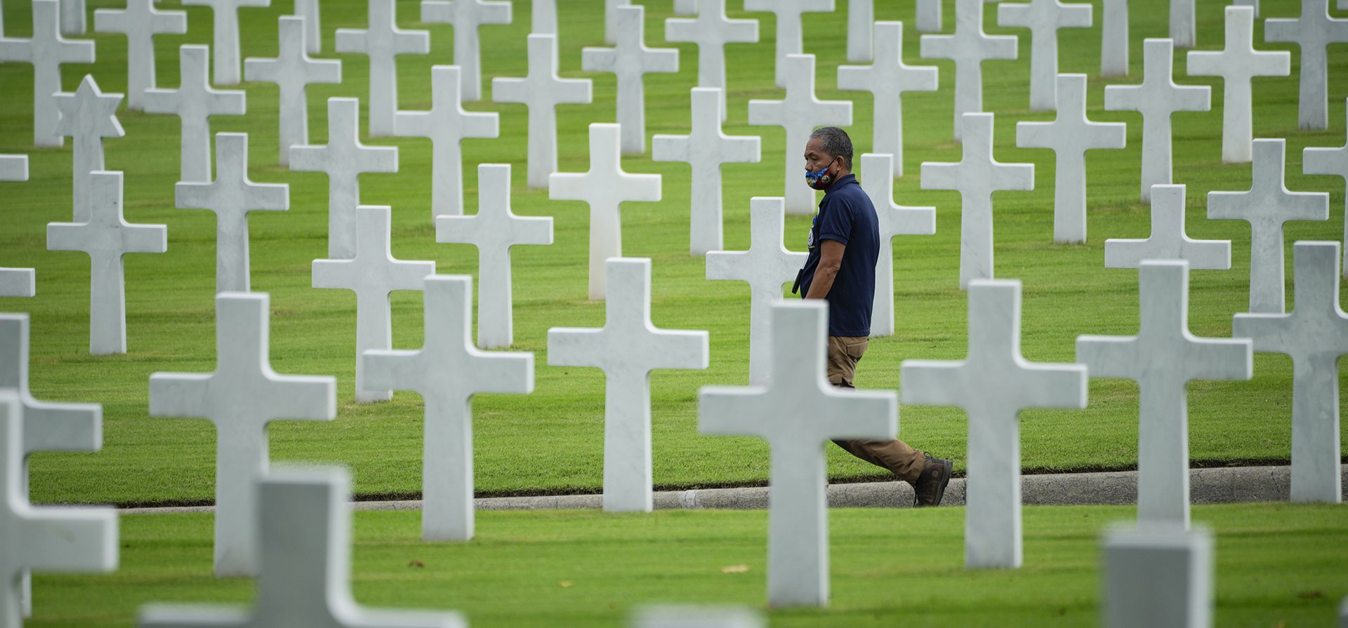 Un hombre pasa junto a filas de cruces después de una ceremonia para conmemorar el Día de los Veteranos de EE. UU. en el Cementerio y Monumento Americano de Manila en el área metropolitana de Manila, Filipinas, el viernes 11 de noviembre de 2022.