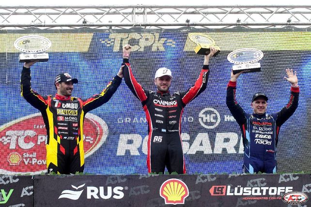 Canapino festeja, flanqueado por Ardusso y Fritzler.