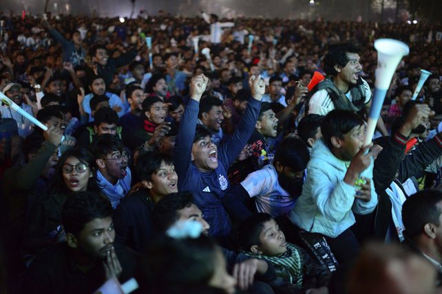 Bangladesh&iacute;es festejan un gol argentino en el partido ante Croacia en una pantalla gigante en un club barrial de Dhaka, Bangladesh.