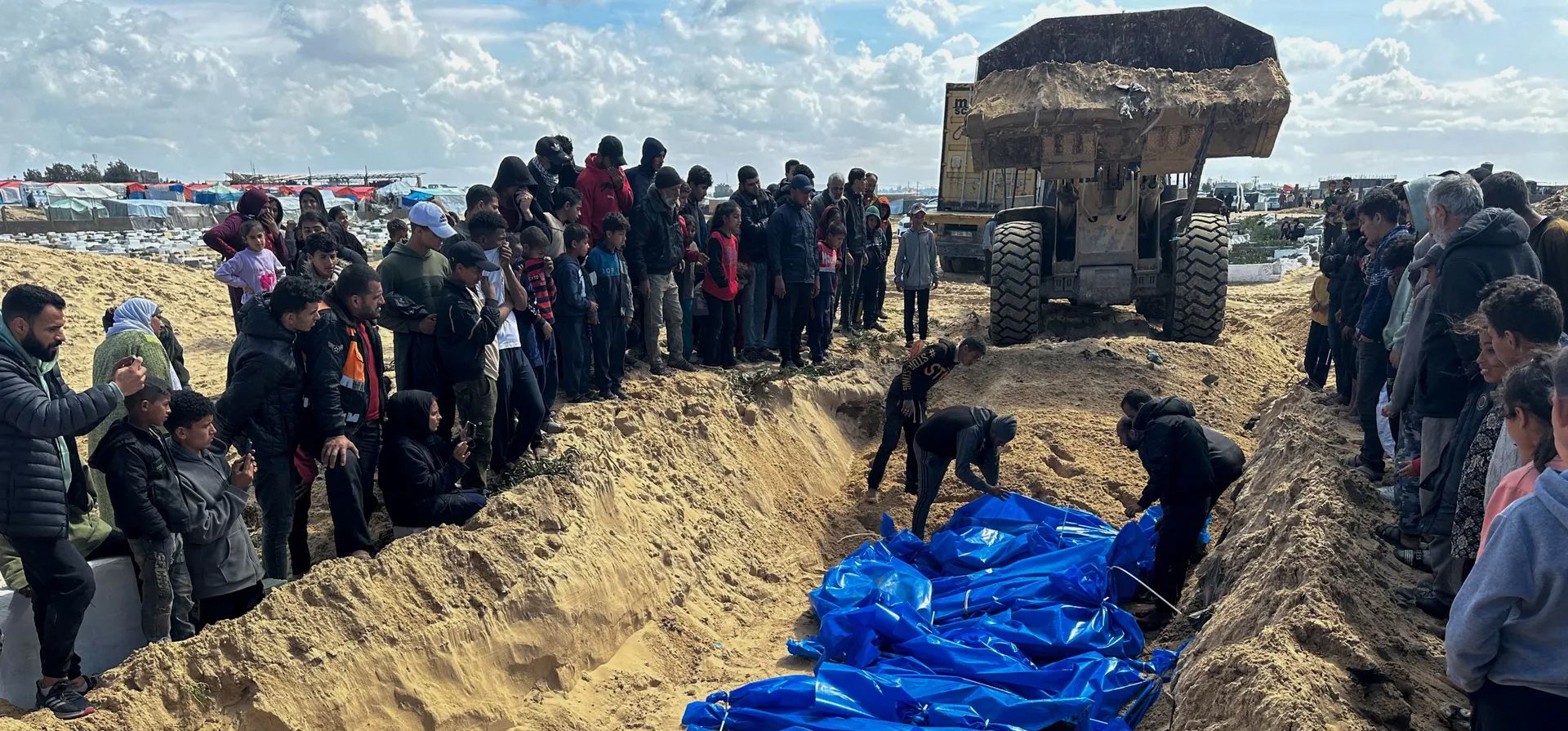La gente entierra en una fosa común los cuerpos de los palestinos muertos en ataques aéreos israelíes, Rafá, Gaza. Fotografía: Mohammed Salem/Reuters La gente entierra en una fosa común los cuerpos de los palestinos muertos en ataques aéreos israelíes, Rafá, Gaza. Fotografía: Mohammed Salem/Reuters