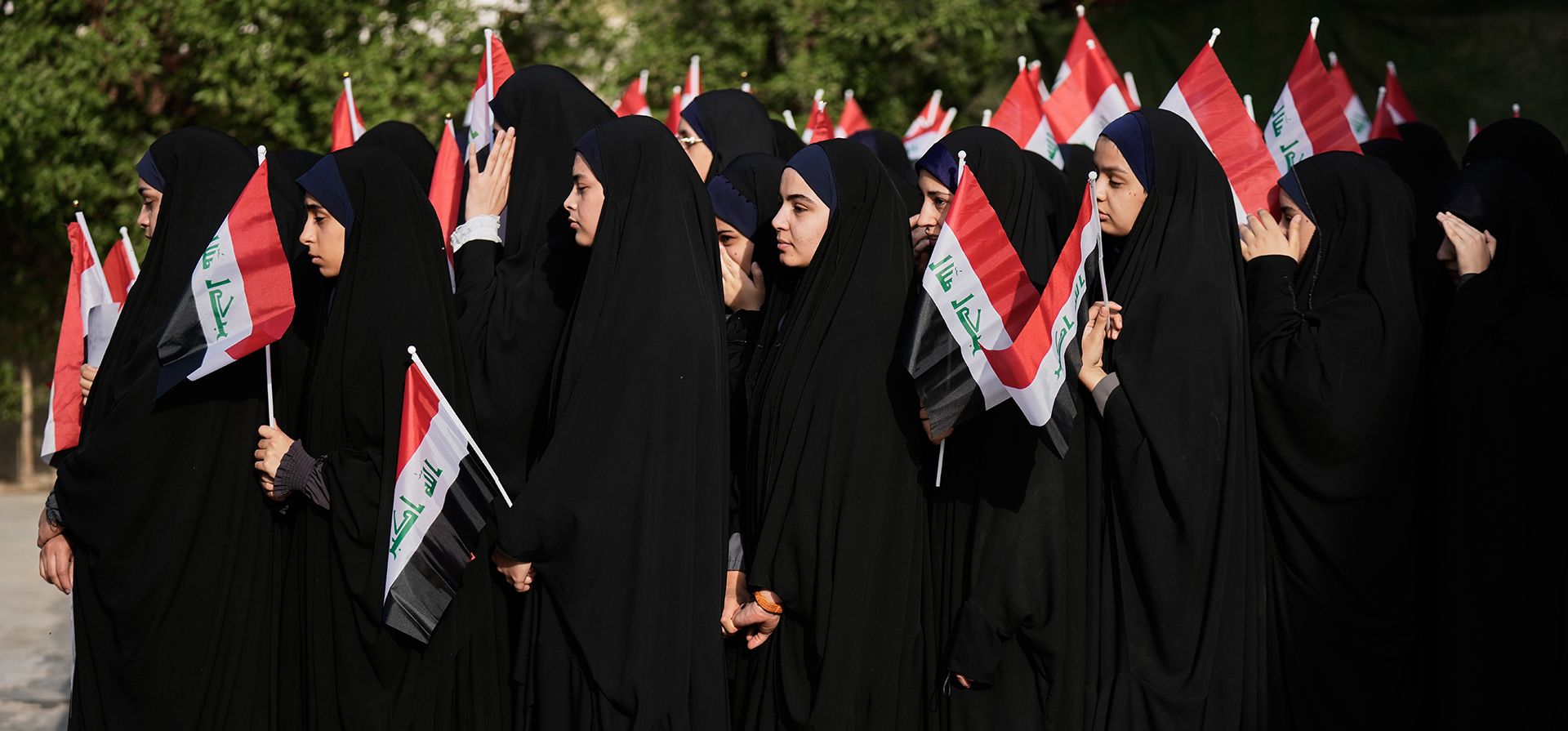 Estudiantes iraquíes sostienen banderas de Irak en una escuela secundaria de Ciudad Sadr, en las afueras de Bagdad, Irak, el jueves 22 de octubre de 2026, en respuesta al llamamiento del clérigo chií Muqtada al-Sadr a protestar contra la decisión de prohibir el hiyab en las escuelas de Azerbaiyán. (Foto AP/Hadi Mizban)