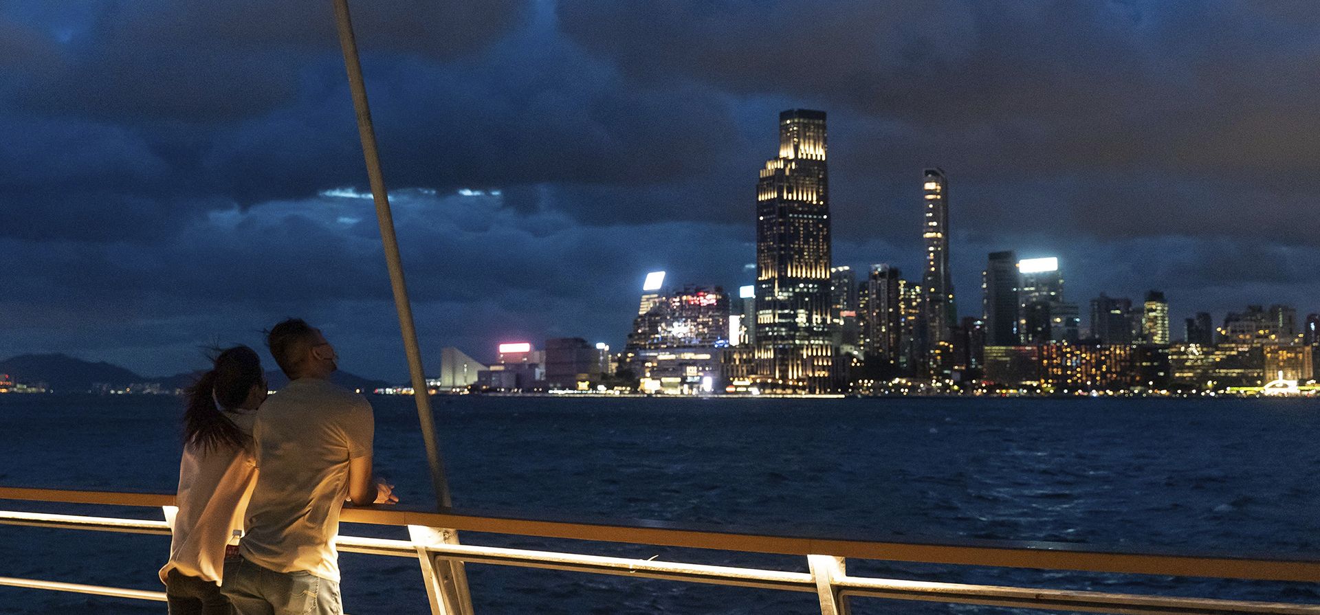 Una pareja observa el puerto de Victoria mientras el ciclón tropical Ma-on se acerca a Hong Kong, el miércoles 24 de agosto de 2022. La tormenta tropical Ma-on ganaba fuerza mientras se dirigía a Hong Kong y otras partes del sureste de China el miércoles después de causar destrozos e inundaciones en Filipinas.