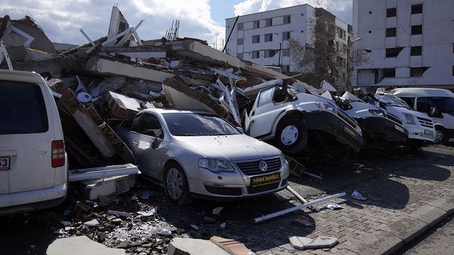 Un edificio destruido cayó sobre vehículos en la ciudad de Nurdagi, en las afueras de la ciudad de Osmaniye, en el sur de Turquía, el martes 7 de febrero de 2023. (Foto AP/Khalil Hamra)
