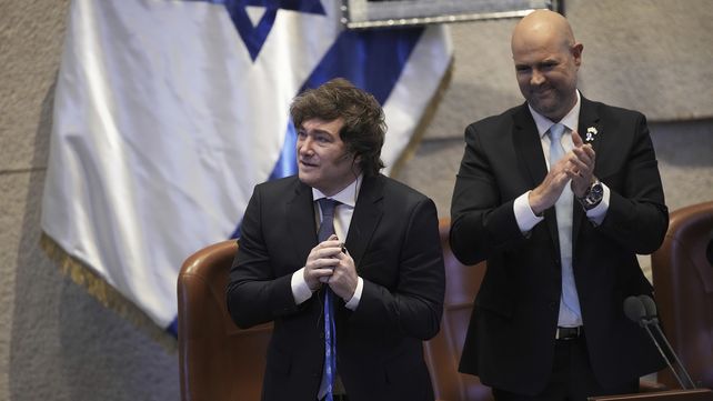 El presidente argentino, Javier Milei, es aplaudido por los legisladores mientras se encuentra junto al presidente del parlamento israelí, Amir Ohana, en el podio de la Knesset, en Jerusalén, el miércoles 11 de junio de 2025. (Foto AP/Ohad Zwigenberg)