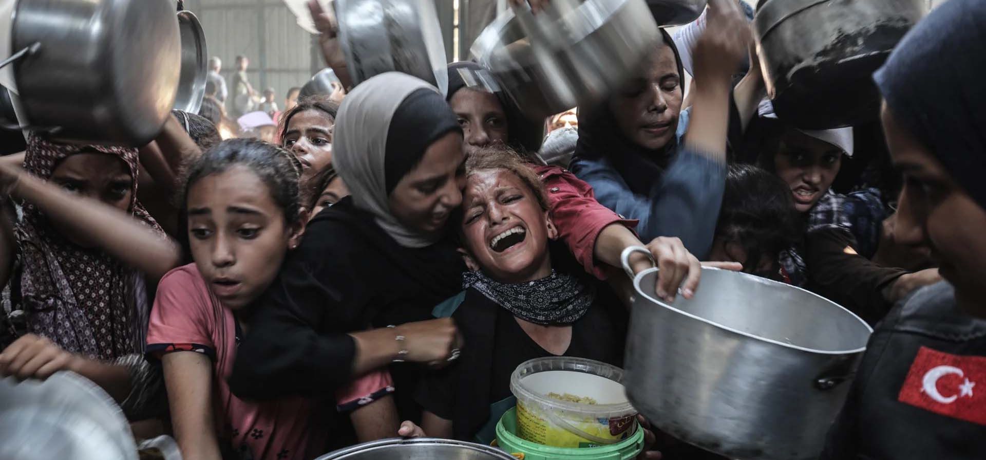 Palestinos, con ollas y sartenes, hacen fila para recibir comidas calientes mientras una organización benéfica distribuye alimentos en el campamento de Nuseirat en medio del bloqueo israelí en curso y los ataques que restringen severamente el acceso a los alimentos. Ciudad de Gaza. Fotografía: Anadolu/Getty Images Palestinos, con ollas y sartenes, hacen fila para recibir comidas calientes mientras una organización benéfica distribuye alimentos en el campamento de Nuseirat en medio del bloqueo israelí en curso y los ataques que restringen severamente el acceso a los alimentos. Ciudad de Gaza. Fotografía: Anadolu/Getty Images