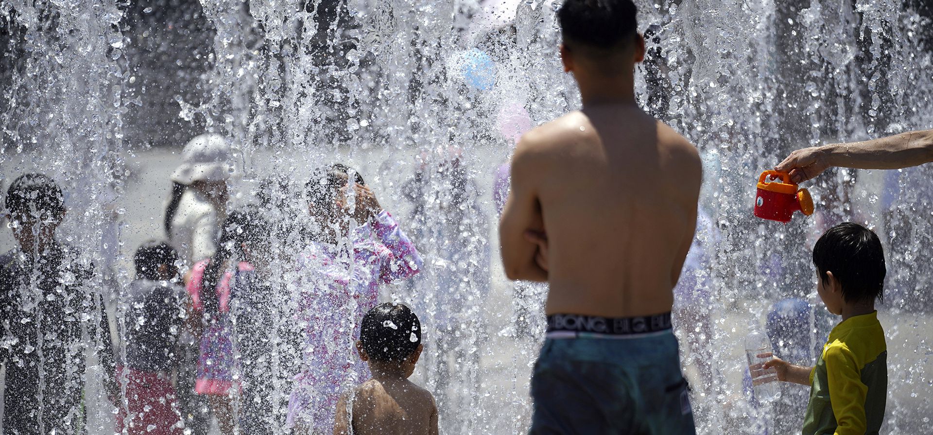 La gente se refresca en una fuente bajo un clima cálido y soleado. El clima cálido continúa en el área metropolitana a medida que las temperaturas superan los 37º grados . (Foto AP/Eugene)