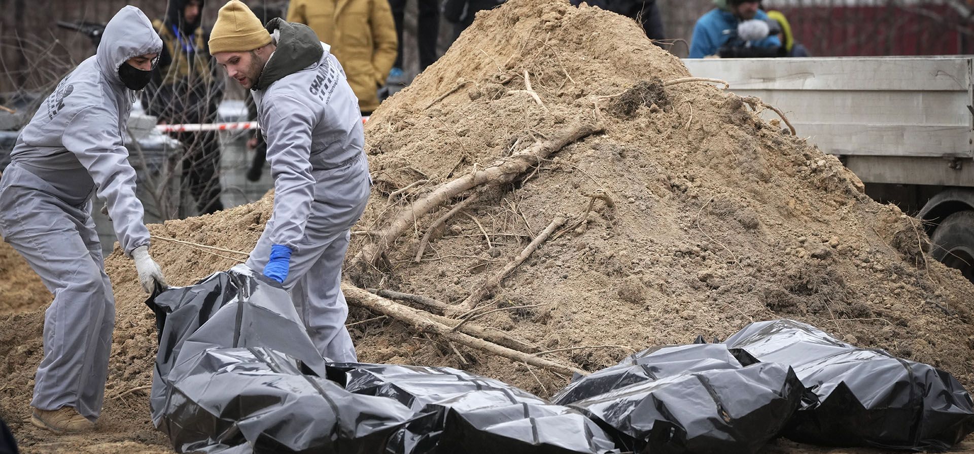 Hombres con equipo de protección exhuman los cuerpos de los civiles asesinados durante la ocupación rusa en Bucha, en las afueras de Kiev, Ucrania, el miércoles 13 de abril de 2022. Decenas de cuerpos de civiles ejecutados por las tropas rusas ya han sido exhumados de la fosa común.