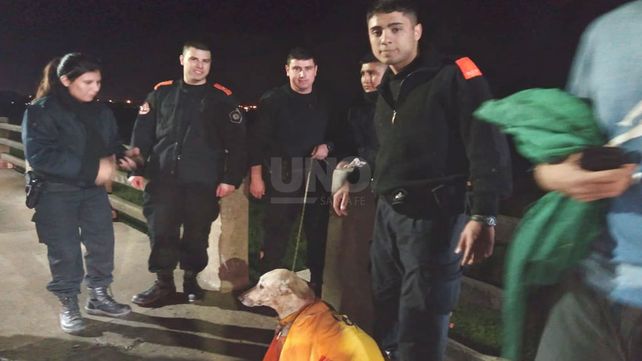 Personal policial junto al perrito rescatado de las aguas del río Salado