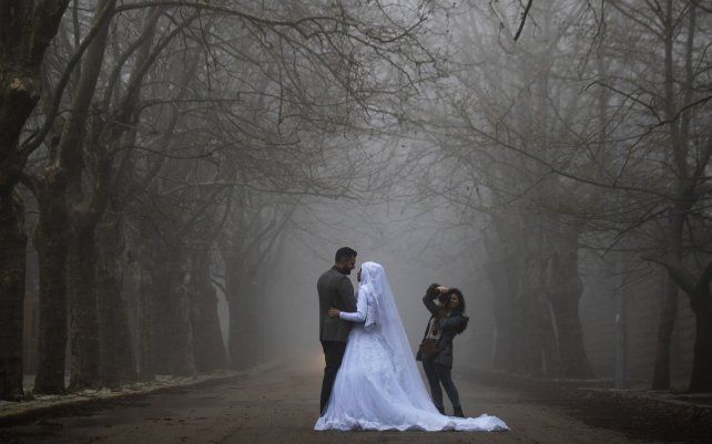 Una pareja de novios posan para una sesión de fotos de boda mientras una densa niebla envuelve la aldea de Sawfar, en la gobernación del Monte Líbano en el Líbano.