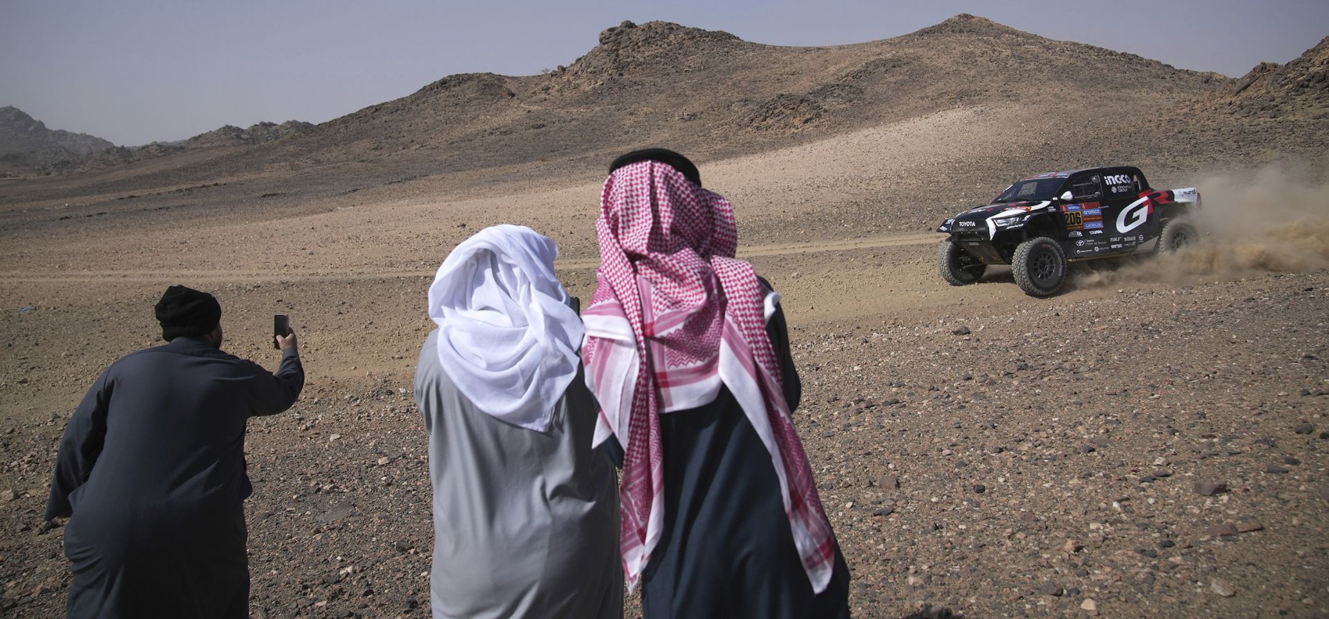 La gente toma fotografías del piloto Giniel De Villiers y el copiloto Dirk Von Zitzewitz durante el prólogo del Rally Dakar en Bisha, Arabia Saudita, el viernes 3 de enero de 2025. (Foto AP/Christophe Ena)