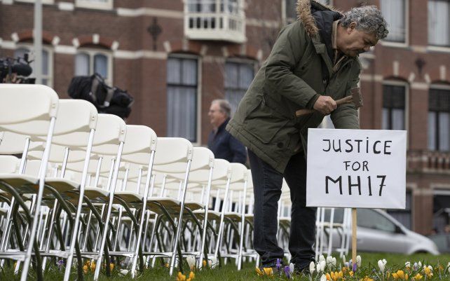 Foto de archivo: 8 de marzo de 2020, Rob Fredriksz, quien perdió a su hijo Bryce y a su novia Daisy, coloca un letrero junto a 298 sillas vacías, representando al vuelo MH17 de Malaysia Air derribado, en un parque frente a la embajada rusa en La Haya, Países Bajos.