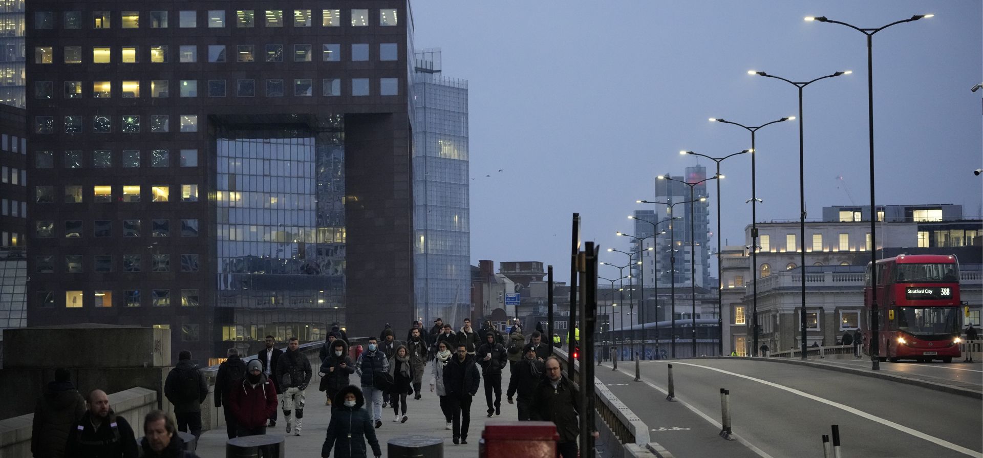 Una gran cantidad de personas caminan sobre el puente de Londres hacia el distrito financiero de la ciudad durante el viaje matutino, en Londres, el lunes 24 de enero de 2022. El gobierno británico ha pedido a las personas que vuelvan a trabajar en las oficinas a partir del lunes a medida que alivian las restricciones por el coronavirus. 