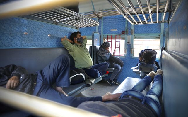 Pasajeros varados se sientan dentro de un tren en la estación de tren de Ganaur mientras los agricultores bloquean las vías del tren durante una protesta que denuncia leyes agrícolas cerca de Sonepat