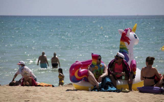 Turistas toman el sol en una playa de la isla de Mallorca, España. Europa se está abriendo a los estadounidenses y otros visitantes después de más de un año de restricciones inducidas por COVID. 