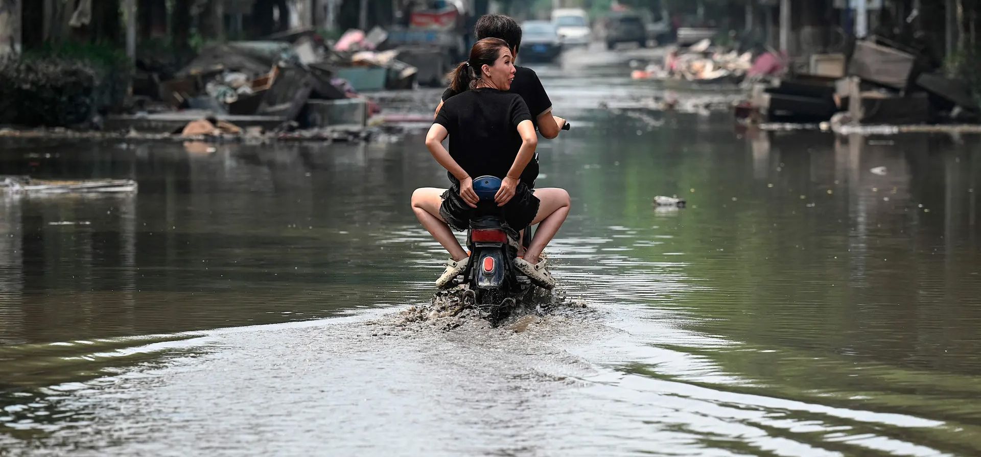 Ciudad de Zhuozhou, China. Residentes locales cruzan en scooter una calle inundada después de fuertes lluvias. Fotografía: Jade Gao/AFP/Getty Images Ciudad de Zhuozhou, China. Residentes locales cruzan en scooter una calle inundada después de fuertes lluvias. Fotografía: Jade Gao/AFP/Getty Images