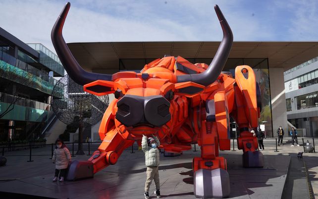 Un niño posa en una escultura de buey instalada para conmemorar el Año Nuevo chino del Buey en Beijing. Los chinos de todo el país regresan al trabajo después de una semana de vacaciones para los chinos.