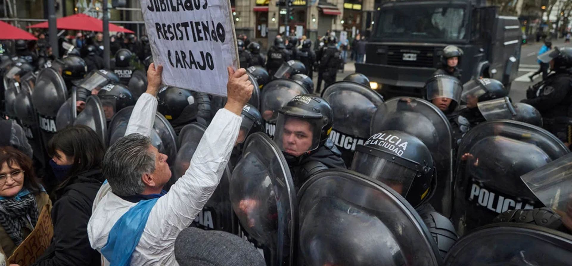 Un manifestante sostiene un cartel con un mensaje que dice: 