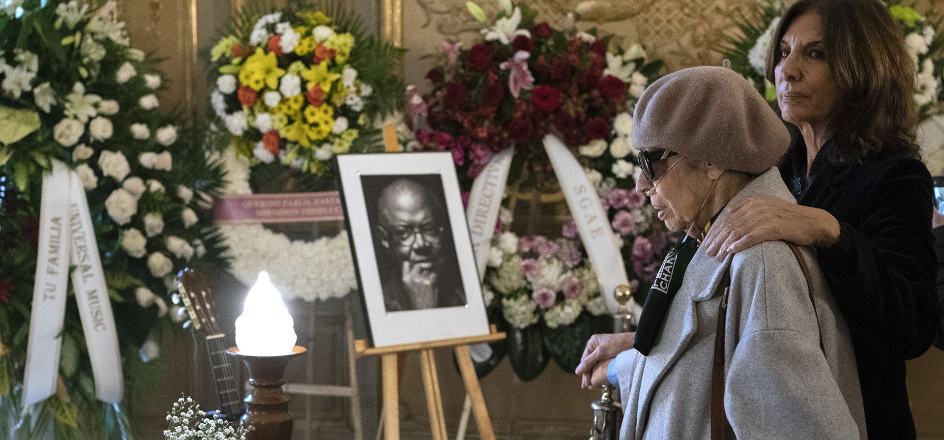 Maritchu Rosado, a la izquierda, viuda del músico español Luis Eduardo Aute, y la actriz española Pastora Vega presentan sus respetos frente al ataúd del cantante cubano Pablo Milanés en la Casa de América en Madrid, España, el miércoles 23 de noviembre de 2022.