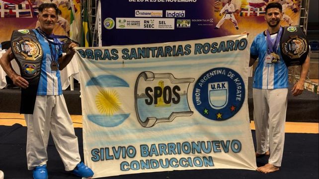 Daniel y Tomás Rosetto posan con orgullo con los cinturones conseguidos en Brasil y la bandera del sindicato que los apoya. El karate rosarino
