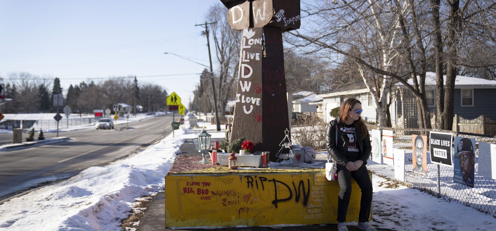 Una joven espera en el monumento a Daunte Wright, que se leyeran los veredictos de culpabilidad de Kimberly Potter el jueves 23 de diciembre de 2021 en Brooklyn Center, Minnesota. Los planes para derribar el monumento en la intersección suburbana de Minneapolis donde Wright fue asesinado a tiros por un oficial de policía están en espera después de que su familia se quejó.