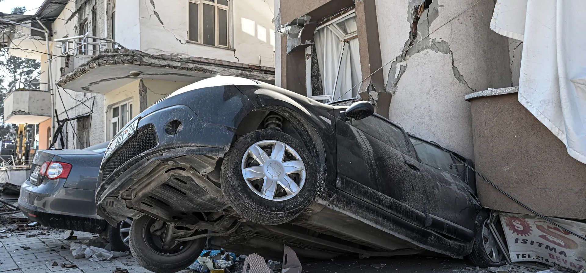 Una vista de un edificio derrumbado en un automóvil en el distrito de Antakya. Dos terremotos sacudieron la provincia de Hatay el lunes, solo dos semanas después de que grandes terremotos azotaran la región. Fotografía: Agencia Anadolu/Getty Images
