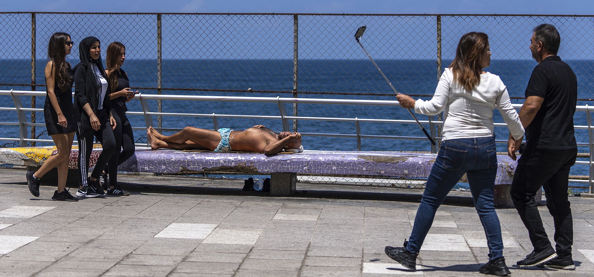 Un hombre toma el sol, en el centro, mientras la gente pasa por el paseo marítimo de Beirut, a orillas del mar Mediterráneo, en un día sofocante, en Beirut, Líbano, el viernes 26 de julio de 2024. (Foto AP/Hassan Ammar) Un hombre toma el sol, en el centro, mientras la gente pasa por el paseo marítimo de Beirut, a orillas del mar Mediterráneo, en un día sofocante, en Beirut, Líbano, el viernes 26 de julio de 2024. (Foto AP/Hassan Ammar)