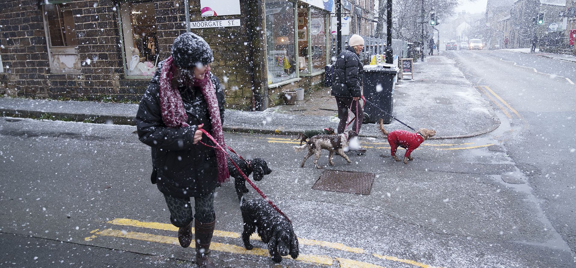 Residentes pasean a sus perros en medio de una intensa nevada en la calle principal de Saddleworth, Inglaterra, el martes 7 de enero de 2025. (Foto AP/Jon Super) Residentes pasean a sus perros en medio de una intensa nevada en la calle principal de Saddleworth, Inglaterra, el martes 7 de enero de 2025. (Foto AP/Jon Super)