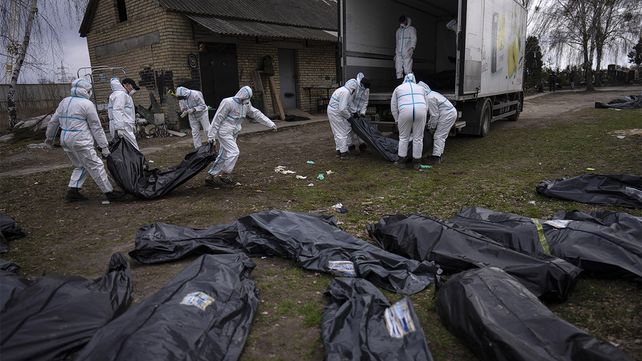 Voluntarios cargan los cuerpos de los civiles asesinados en Bucha en un camión para llevarlos a una morgue para su investigación, en las afueras de Kiev, Ucrania.