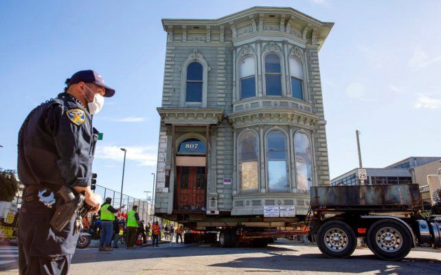 Un agente de policía de San Francisco supervisa el traslado de la conocida casa, como Englander House en un cruce de calles.