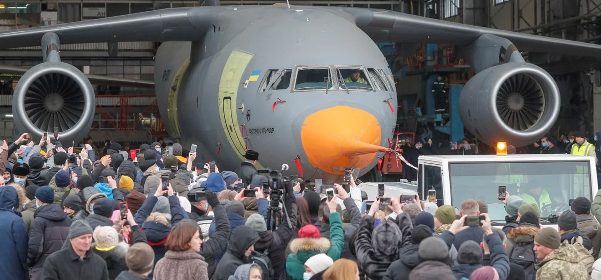 Trabajadores de la planta aeronáutica ven cómo el primer nuevo avión Antonov An-178-100R, que está listo para las pruebas de certificación de vuelo, es sacado de un hangar durante su presentación en la Empresa Estatal Antonov en Kiev, Ucrania. El nuevo avión de transporte militar ucraniano Antonov An-178-100R está diseñado para transportar hasta 100 personas, equipo, carga, personal de tropas aerotransportadas. Foto: EFE