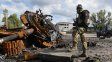 Un soldado ucraniano posa junto a los restos de un tanque ruso.