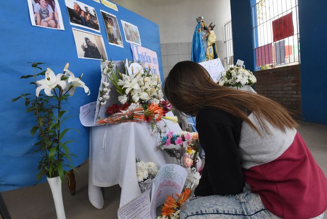 Una compañera de Ticiana le rinde su homenaje en el altar levantado en la puerta de la escuela a la que concurría.