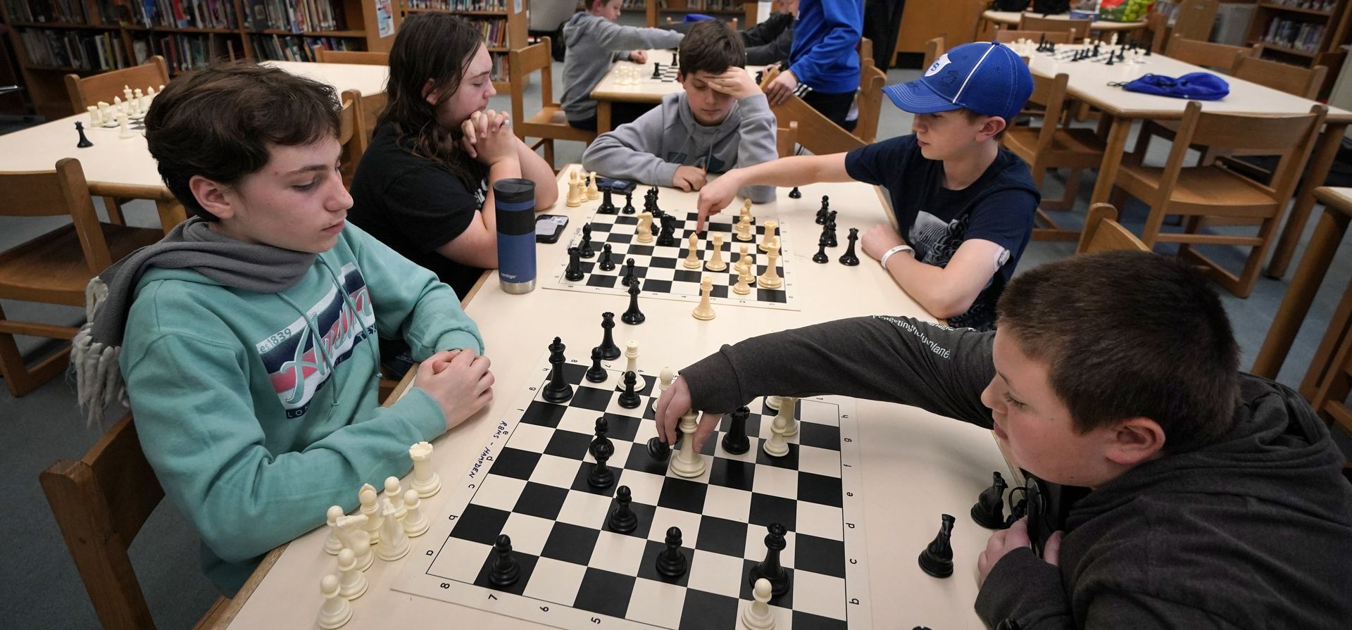 Miembros del equipo de ajedrez de la Escuela Secundaria Reeds Brook practican en la biblioteca de la Academia Hampden, el martes 25 de abril de 2023, en Hampden, Maine. (Foto AP/Robert F. Bukaty)