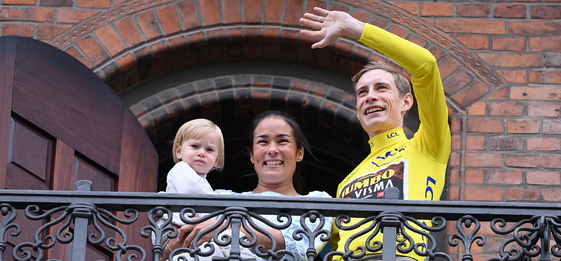 El ciclista danés del equipo Jumbo-Visma y ganador de la edición 109 del Tour de Francia, Jonas Vingegaard, hace un gesto con su novia Trine Marie Hansen y su hija Frida, mientras lo vitorean al regresar del aeropuerto, en el Ayuntamiento de Copenhague en Copenhague, el miércoles 27 de julio. 