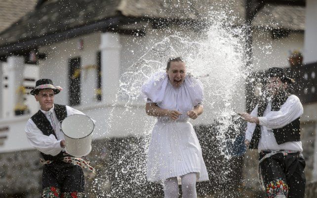 Vestidos con trajes típicos, jóvenes vierten agua sobre mujeres en Holloko, un pueblo de montaña inscrito en la Lista del Patrimonio Mundial de la Unesco, Hungría.