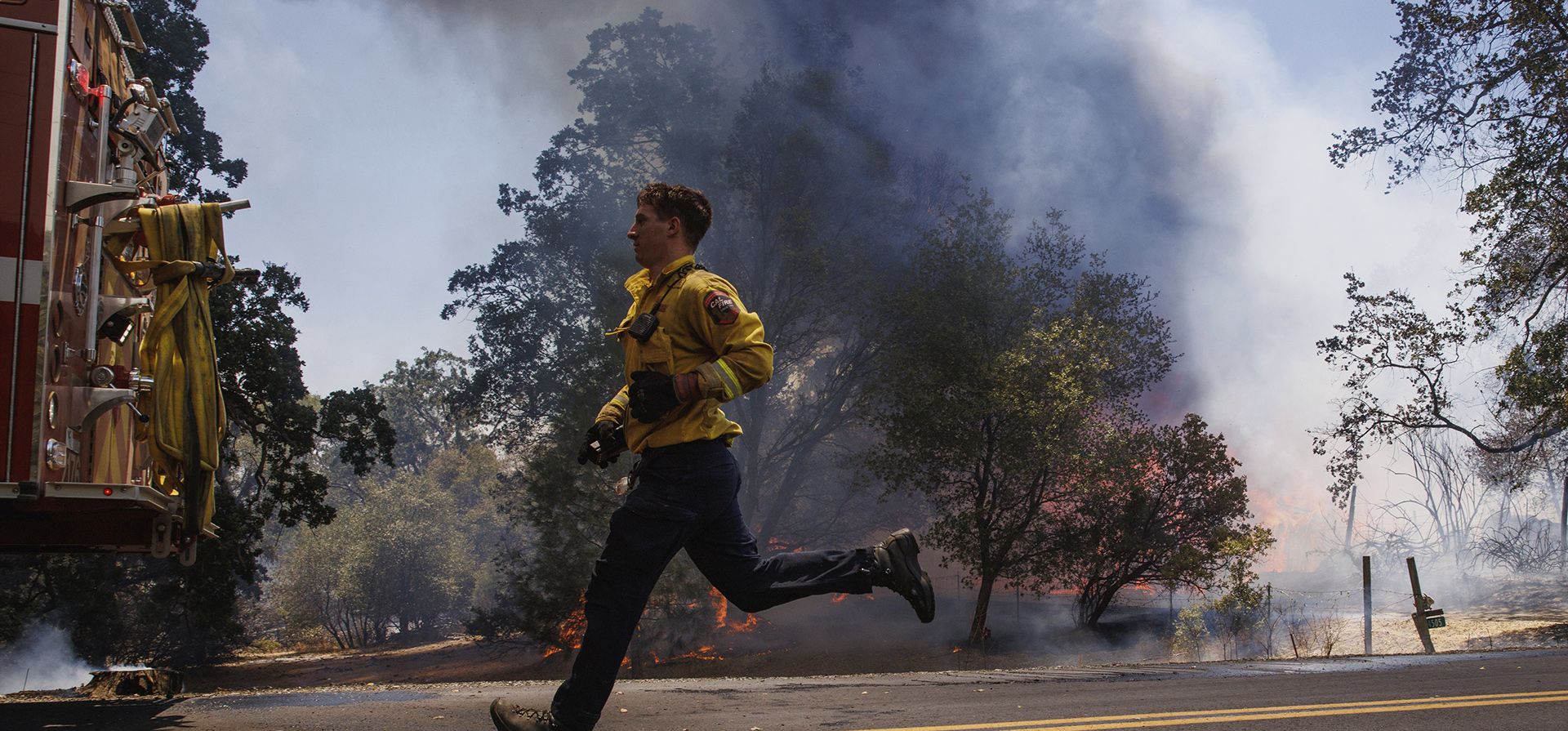 Un bombero corre mientras el incendio Oak arde en Triangle Road en el condado no incorporado de Mariposa, California.