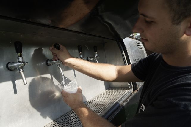 Tomás Perosio muestra la canilla para servir gin desde su foodtruck.