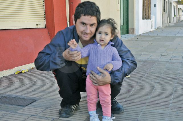 Padre e hija. Rubén y Julieta juegan en la vereda a la espera de que llegue la mamá.