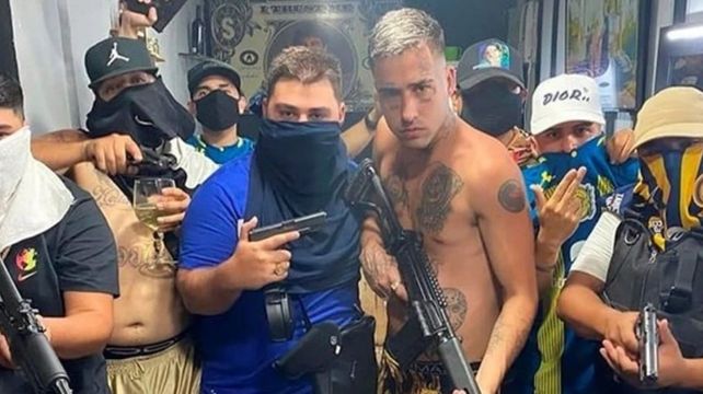 Luciano Uriel “Lucho” Cantero y su gente posando con armas junto al trapero Zaramay en una barbería.