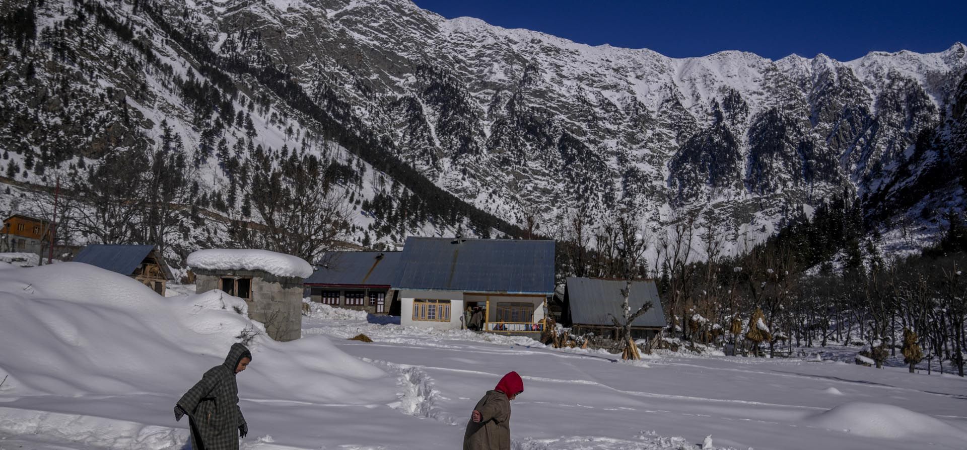 Un niño de Cachemira se desliza por una pendiente usando tubos de goma como esquís en un campo cubierto de nieve en Gagangeer, al noreste de Srinagar, Cachemira controlada por India, el miércoles 12 de enero de 2022.