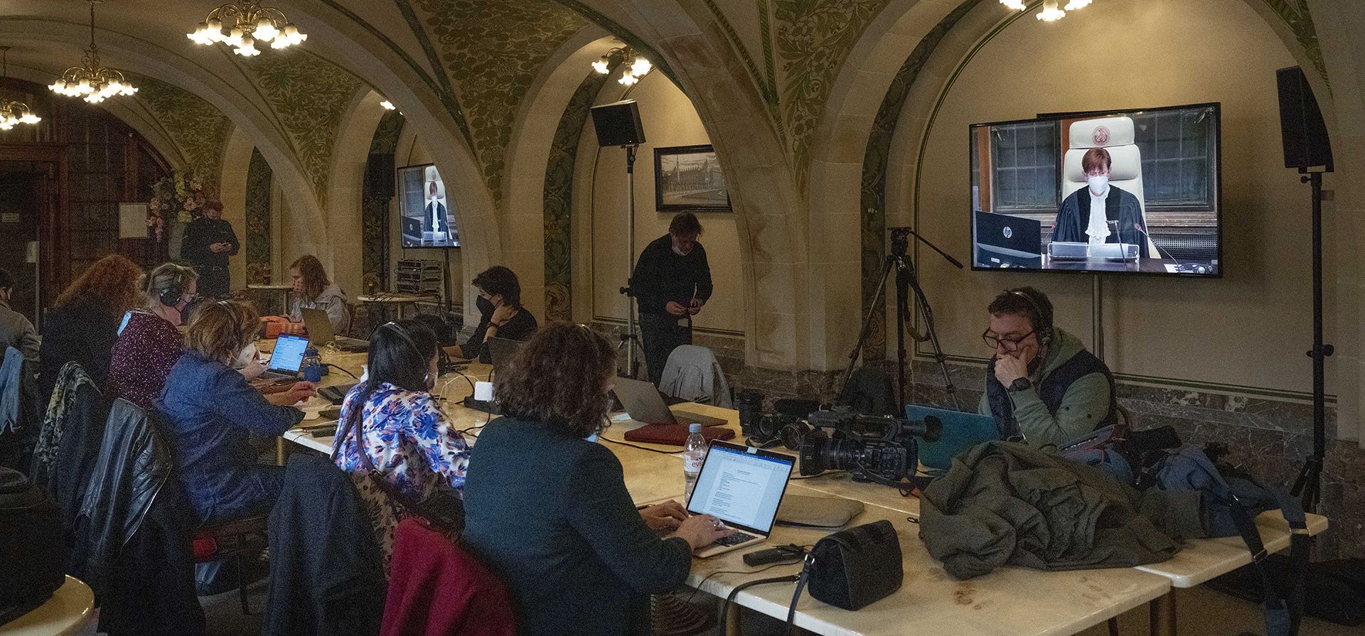 Los periodistas escuchan a la jueza presidente Joan Donoghue, en la pantalla, mientras lee el fallo del tribunal superior de las Naciones Unidas en La Haya, Países Bajos, el miércoles 16 de marzo de 2022, sobre una solicitud de Ucrania para ordenar a Rusia que detenga su devastadora invasión.