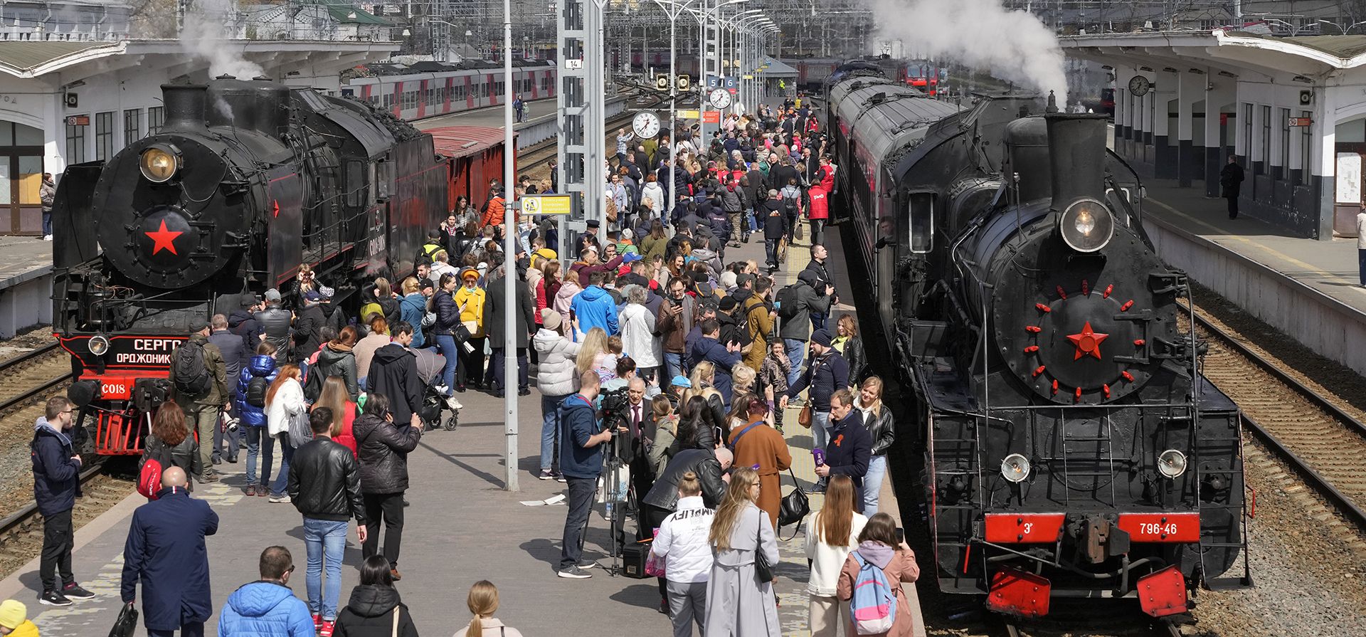 La gente camina entre locomotoras de la época de la Segunda Guerra Mundial en la estación de tren Finlyandsky durante una reconstrucción histórica que marca el 77º aniversario de la victoria en la Segunda Guerra Mundial en San Petersburgo, Rusia, el viernes 6 de mayo de 2022.