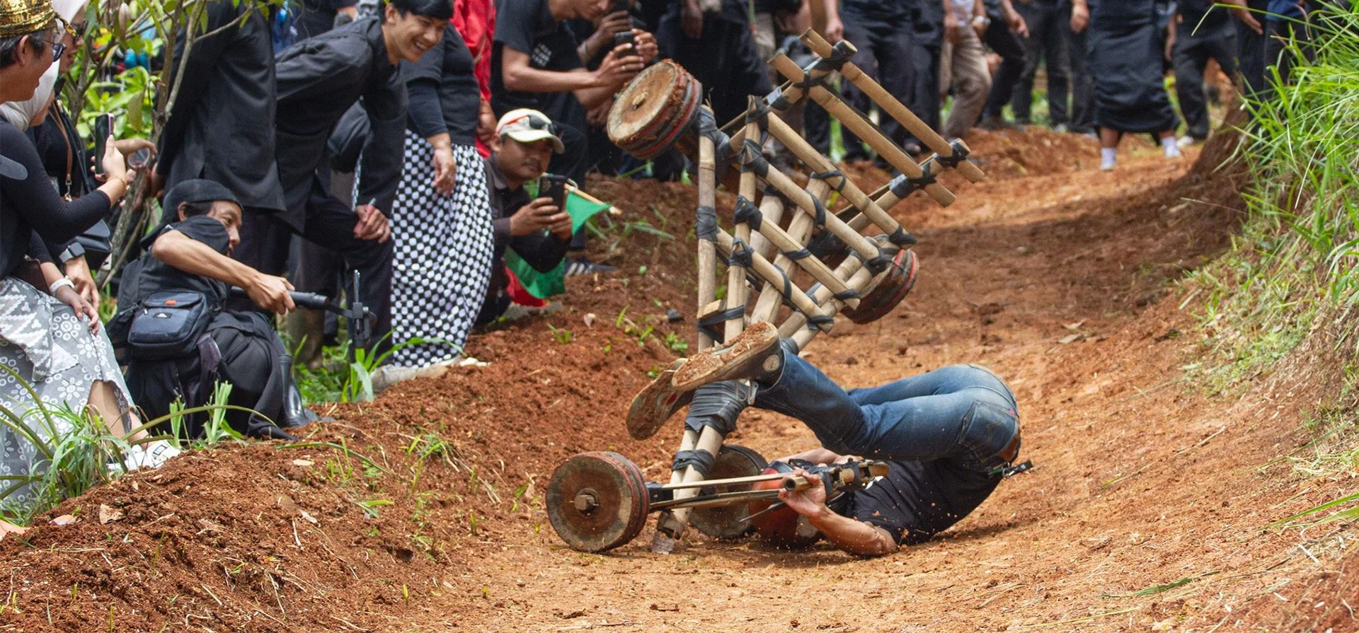 Un hombre se estrella después de deslizarse a gran velocidad desde lo alto de una pista en un automóvil de bambú. El evento contó con la presencia de 30 participantes como parte de un esfuerzo por preservar los juegos tradicionales que han comenzado a ser abandonados, especialmente por los jóvenes, Bandung, Indonesia. Fotografía: Algi Febri Sugita/Zuma Press/Rex/Shutterstock Un hombre se estrella después de deslizarse a gran velocidad desde lo alto de una pista en un automóvil de bambú. El evento contó con la presencia de 30 participantes como parte de un esfuerzo por preservar los juegos tradicionales que han comenzado a ser abandonados, especialmente por los jóvenes, Bandung, Indonesia. Fotografía: Algi Febri Sugita/Zuma Press/Rex/Shutterstock