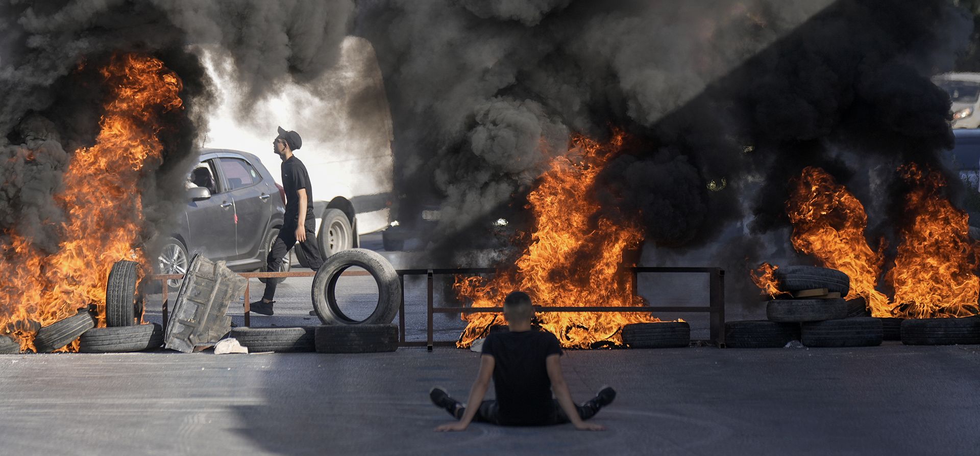 Jóvenes queman neumáticos en el sitio donde dos palestinos fueron asesinados a tiros por el ejército israelí en el campo de refugiados de Jalazone cerca de la ciudad de Ramallah, Cisjordania, el lunes 3 de octubre de 2022.