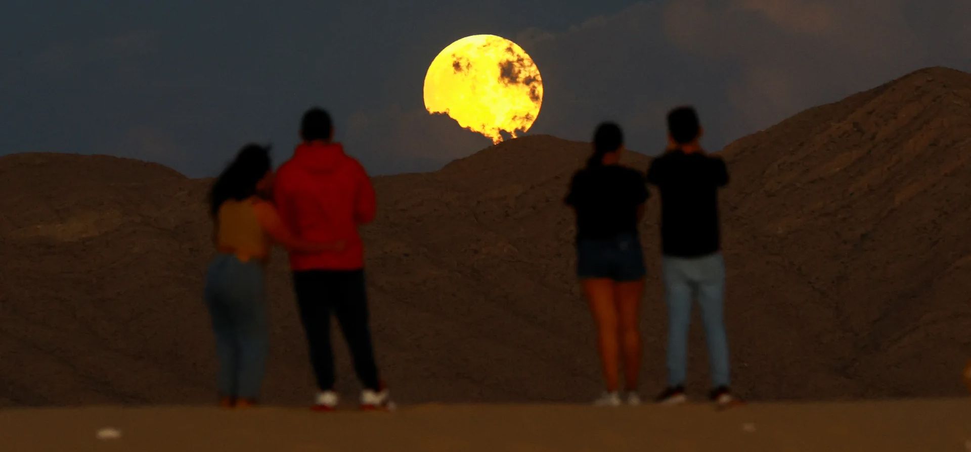 La gente observa la salida de la luna llena antes del eclipse lunar en las Dunas de Samalayuca, Ciudad Juárez, México. Fotografía: José Luis González/Reuters La gente observa la salida de la luna llena antes del eclipse lunar en las Dunas de Samalayuca, Ciudad Juárez, México. Fotografía: José Luis González/Reuters